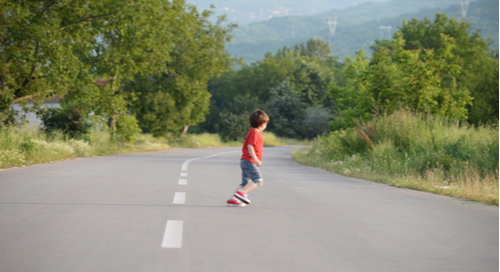 Child running across a road